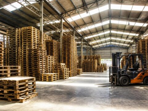 Nakatambak na kahoy na pallet sa isang malaking warehouse